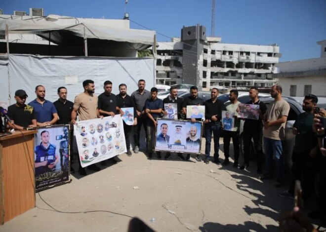 Journalists hold a vigil outside an Al Jazeera tent in Gaza City on the anniversary of the assassination of journalist and correspondent Anas Al-Sharif